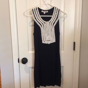 Navy, sleeveless dress with white lace detail.